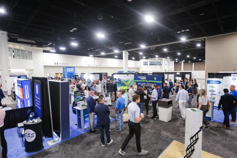 Attendees moving between exhibitor booths in the Connect (X) 2026 exhibit hall